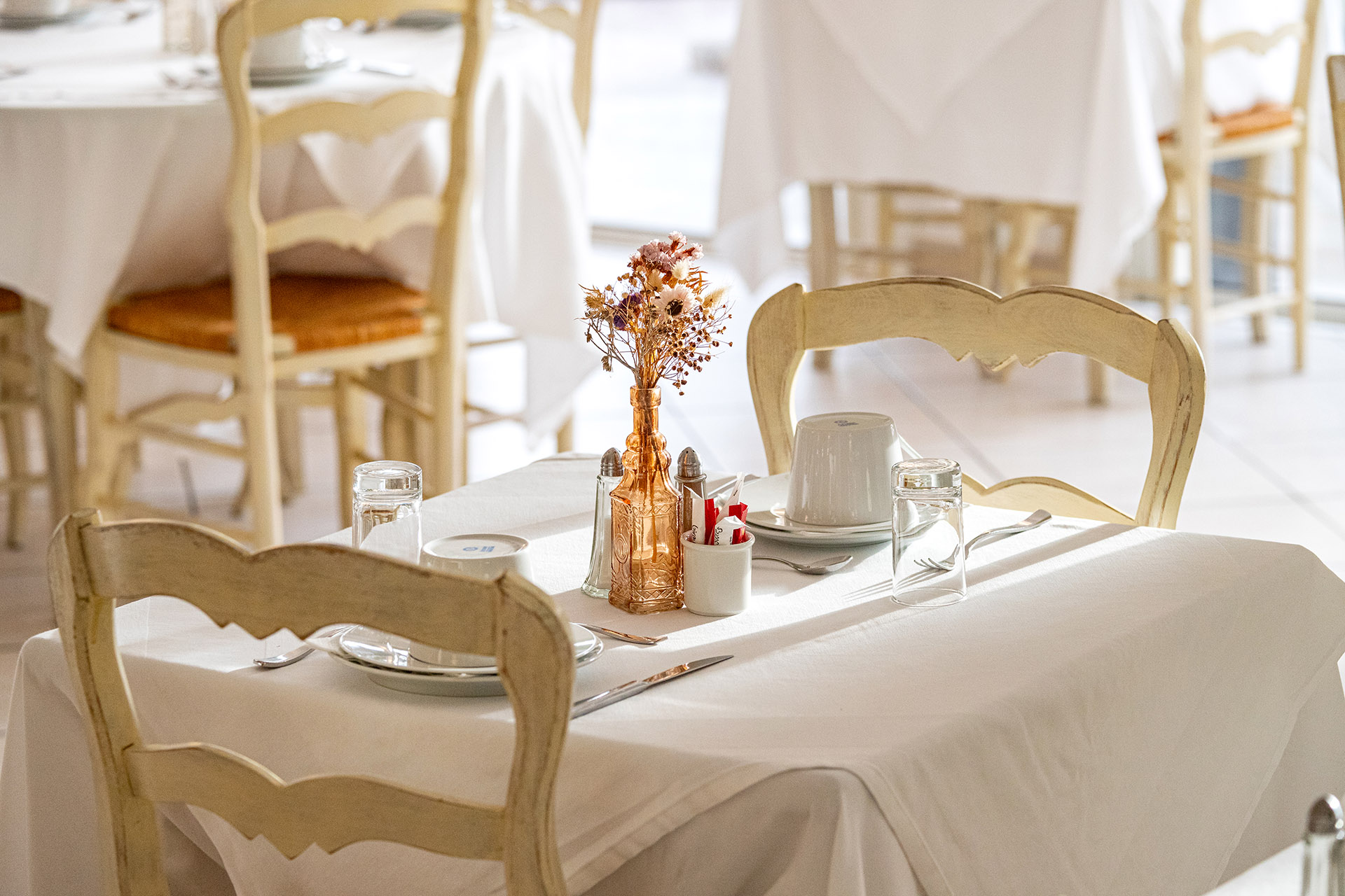 Table de restaurant élégamment dressée dans l’hôtel, ambiance chaleureuse et méditerranéenne