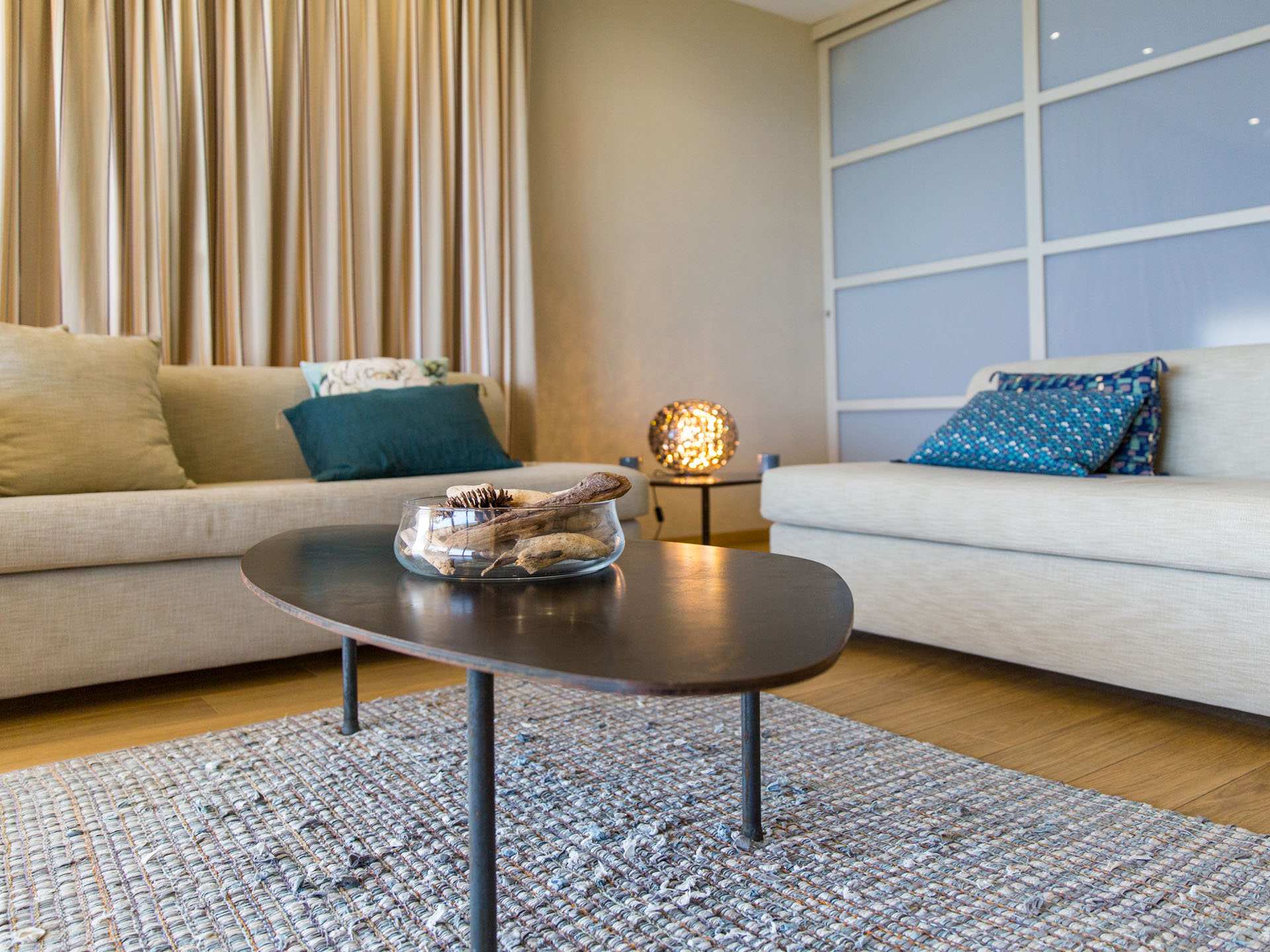 Salon de la suite de l’hôtel avec deux canapés beiges et table basse en bois
