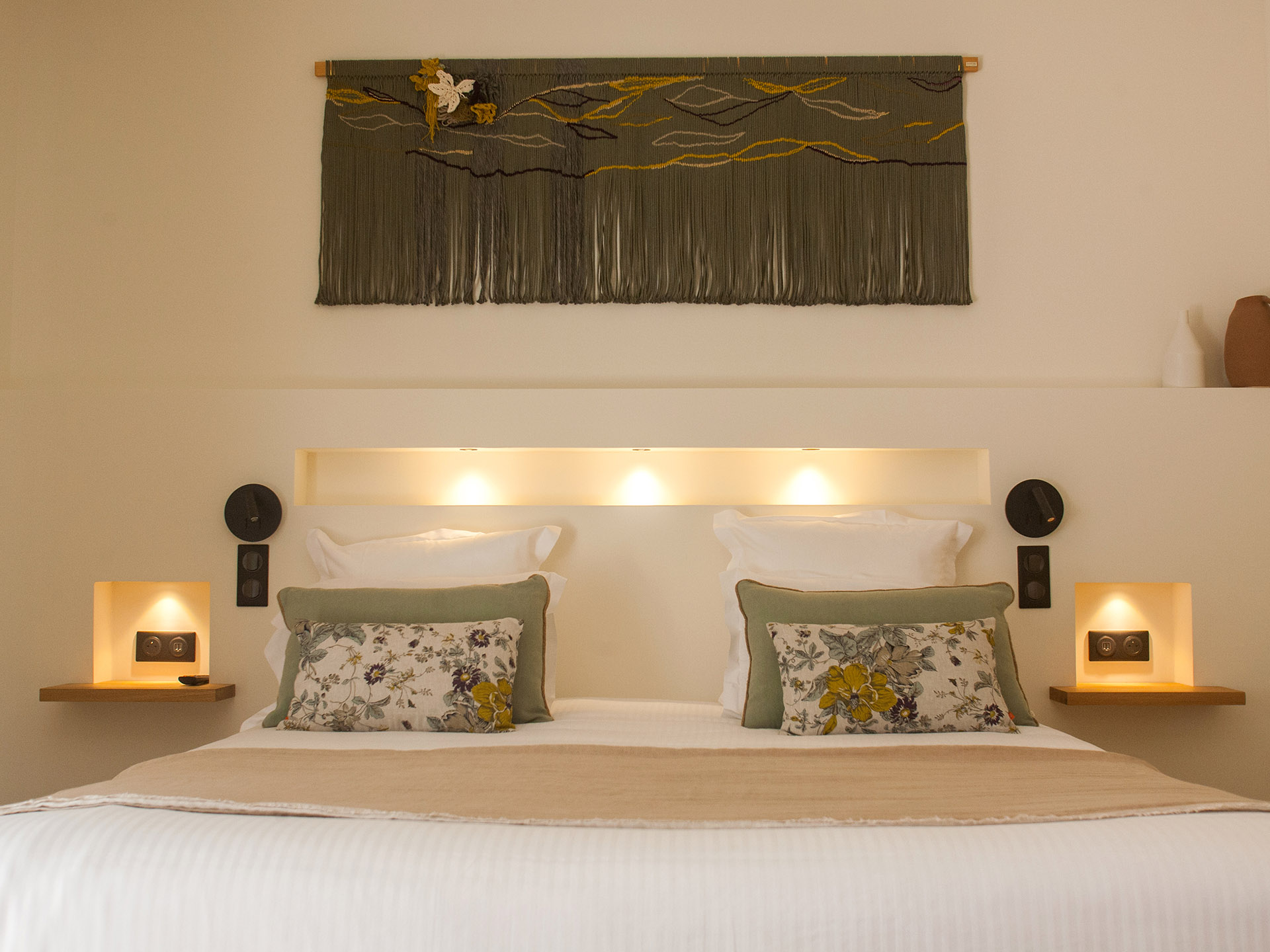 Chambre d’hôtel moderne avec lit double, décoration murale et éclairage intégré